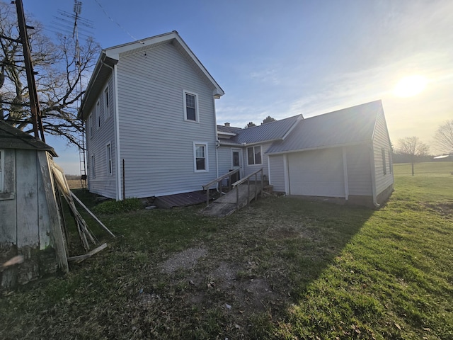 back of house with a garage and a yard