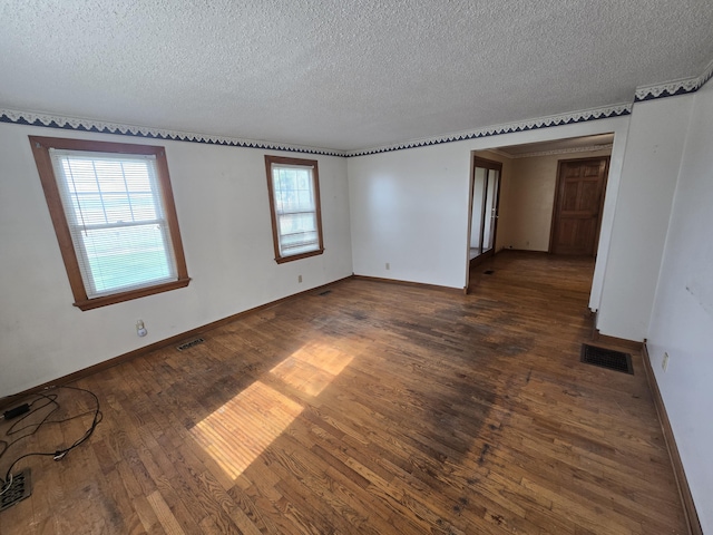 4391 Tamarack Rd, Hillsdale, MI 49242 - spare room with dark wood finished floors, a textured ceiling, visible vents, and baseboards