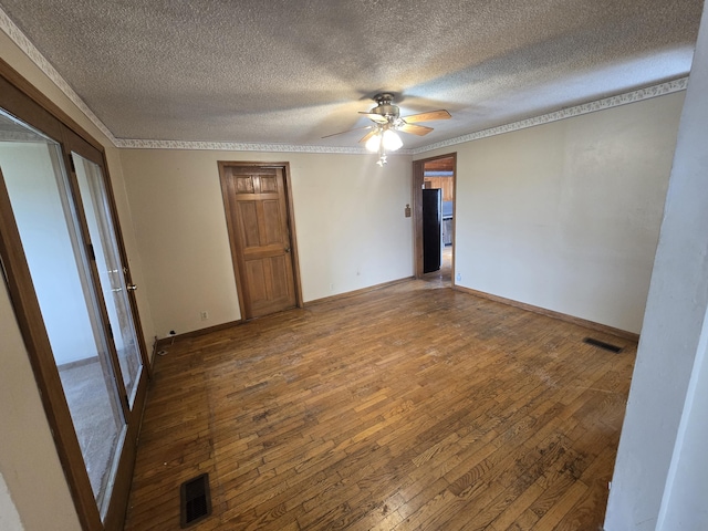 4391 Tamarack Rd, Hillsdale, MI 49242 - empty room featuring a textured ceiling, visible vents, a ceiling fan, and hardwood / wood-style flooring