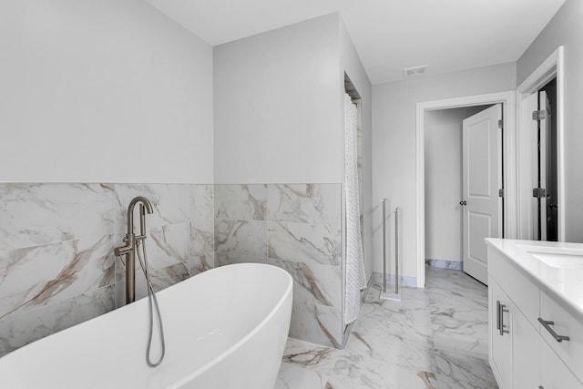 146 Bloomfield Blvd, Brooklyn, MI 49230 - full bathroom with vanity, marble finish floor, wainscoting, tile walls, and a freestanding bath