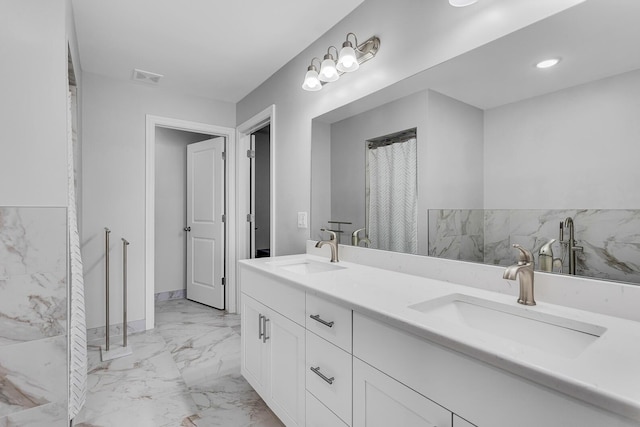 146 Bloomfield Blvd, Brooklyn, MI 49230 - full bathroom featuring double vanity, visible vents, a sink, and marble finish floor