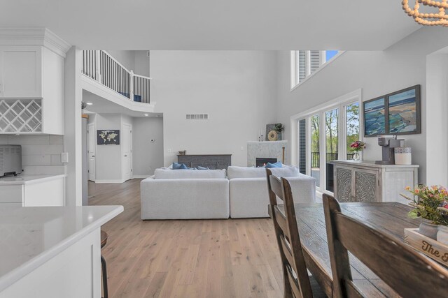 146 Bloomfield Blvd, Brooklyn, MI 49230 - living area with visible vents, a high end fireplace, light wood finished floors, and a towering ceiling