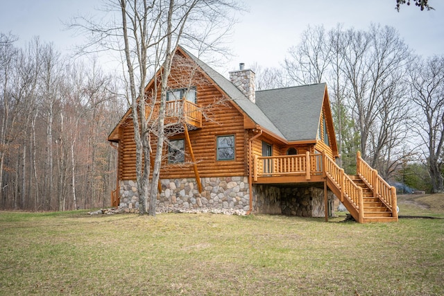 rear view of house with log siding, stone siding, stairway, a chimney, and a lawn