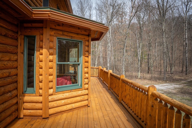 wooden terrace featuring a wooded view