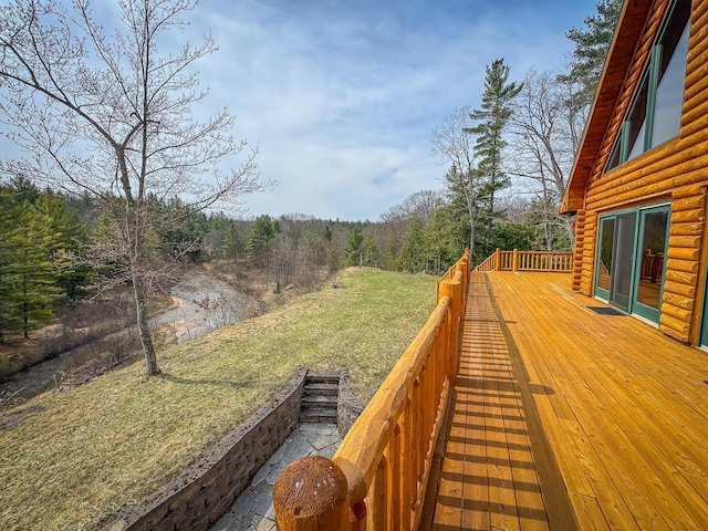 deck featuring a view of trees and a yard