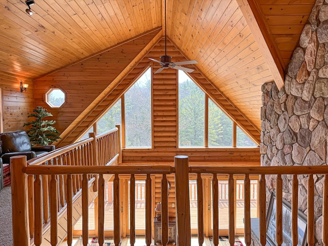 interior details with rustic walls, ceiling fan, and wood ceiling