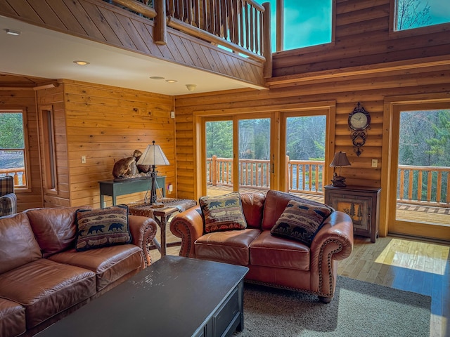 living room with plenty of natural light, recessed lighting, wood-type flooring, and log walls