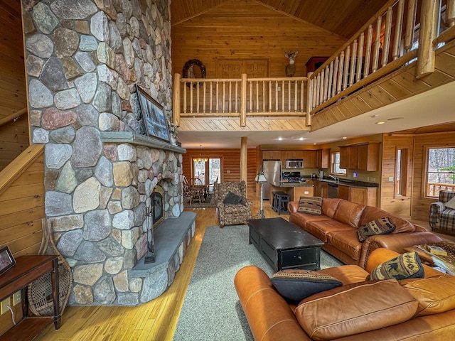 living room with light wood-type flooring, wood walls, and a healthy amount of sunlight