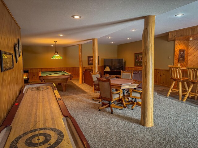 recreation room featuring wooden walls, carpet flooring, and a wainscoted wall