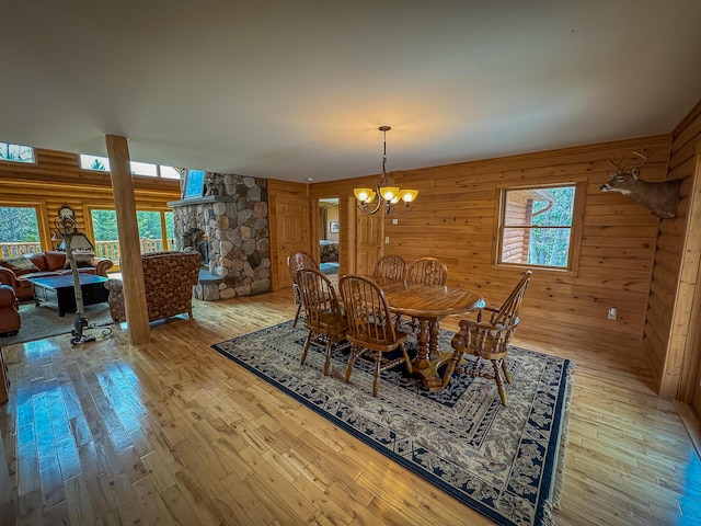 dining room featuring wood walls, hardwood / wood-style floors, and a chandelier