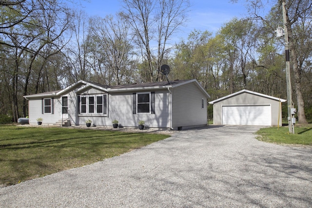 manufactured / mobile home featuring a garage, an outbuilding, a front yard, and entry steps