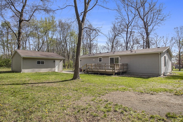 back of property featuring a lawn, a wooden deck, and an outdoor structure