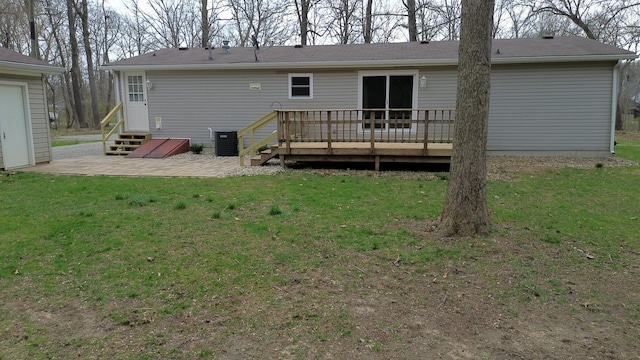 rear view of property featuring a wooden deck, a patio, entry steps, central air condition unit, and a yard
