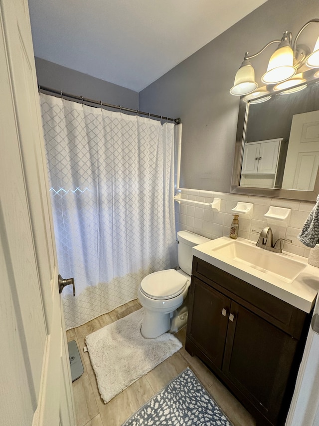 full bathroom with toilet, tile walls, a shower with curtain, wood finished floors, and vanity