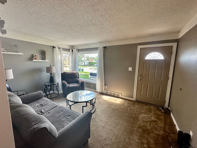 carpeted living room featuring baseboards, visible vents, and a textured ceiling