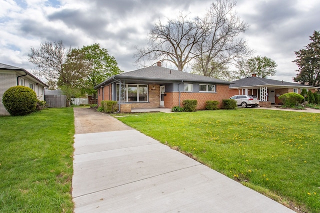 bungalow featuring concrete driveway, brick siding, a chimney, and a front yard