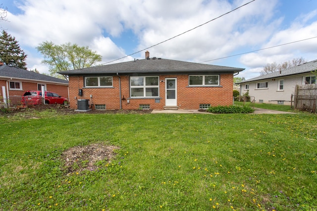 back of house with a lawn, central AC, fence, and brick siding