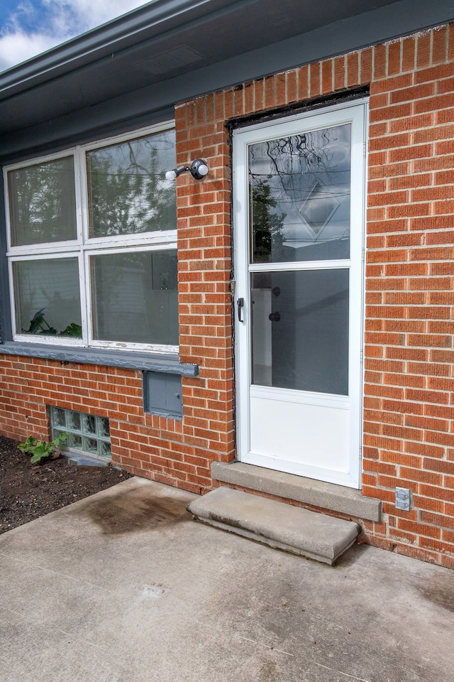 entrance to property featuring brick siding