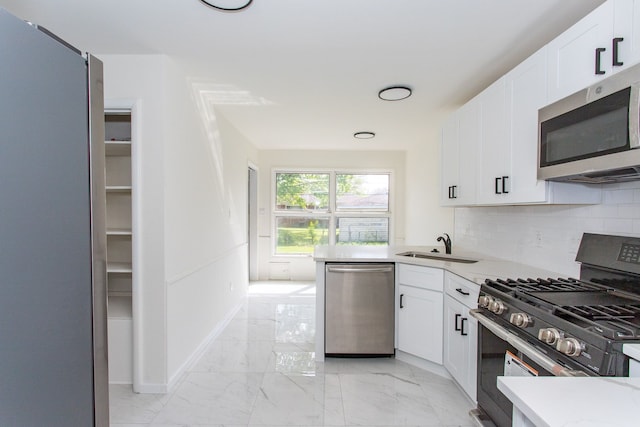 kitchen featuring light countertops, white cabinetry, appliances with stainless steel finishes, and marble finish floor