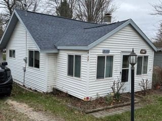 10100 Woodlawn Rd, Saint Helen, MI 48656 - exterior space featuring roof with shingles and a chimney