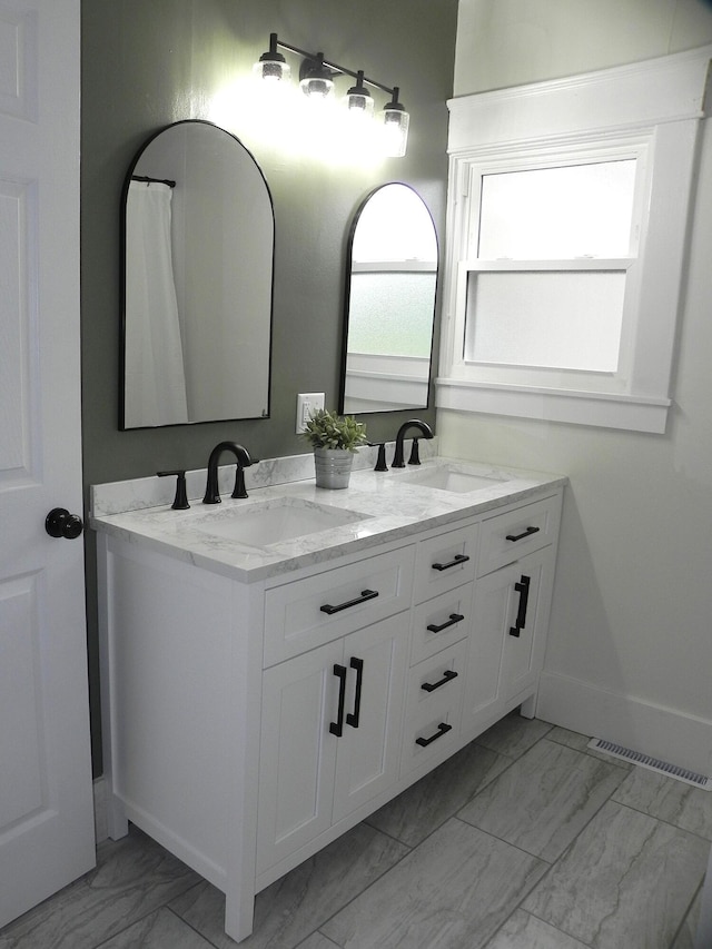 bathroom featuring double vanity, visible vents, a sink, and marble finish floor
