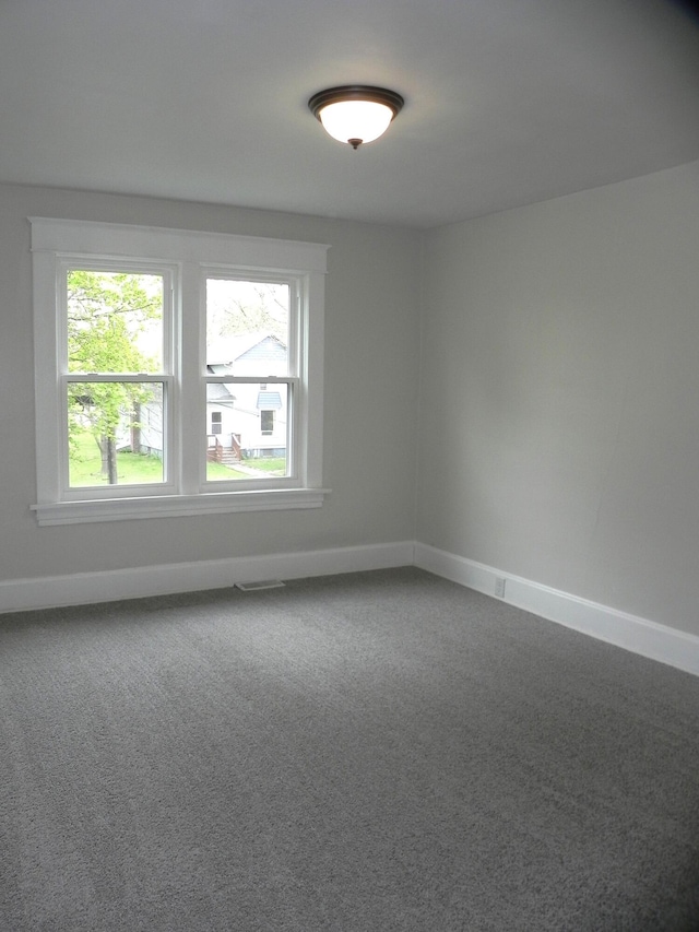 carpeted empty room with baseboards and visible vents