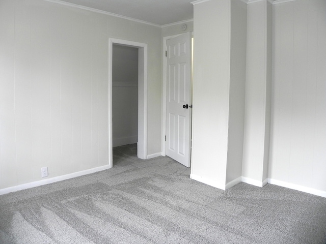 unfurnished bedroom featuring carpet floors, ornamental molding, and baseboards