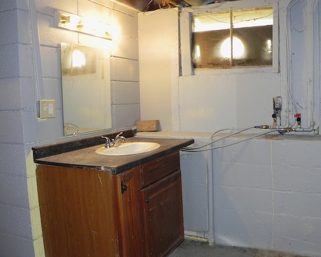 bathroom featuring concrete block wall and vanity