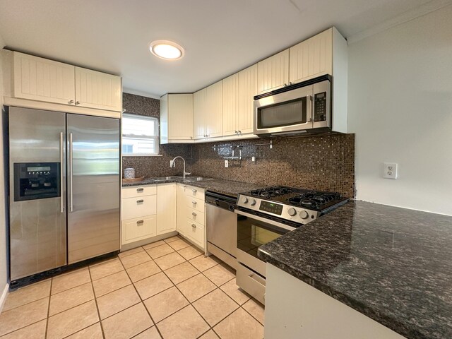 524 E Farnum Ave, Royal Oak, MI 48067 - kitchen featuring decorative backsplash, appliances with stainless steel finishes, a sink, dark stone counters, and light tile patterned flooring