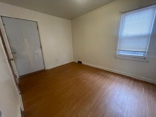 empty room with baseboards and wood finished floors