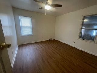 spare room featuring baseboards, a ceiling fan, and wood finished floors