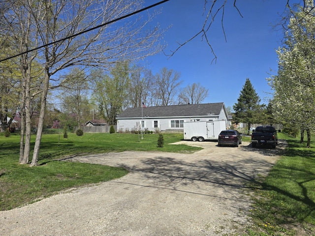 view of front facade with dirt driveway and a front yard