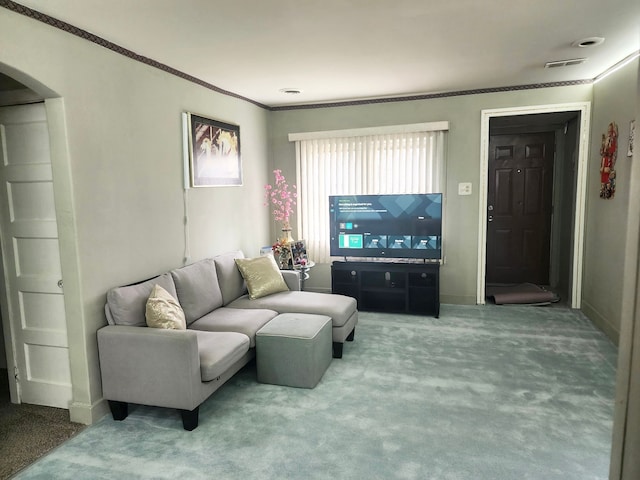 living room featuring arched walkways, baseboards, ornamental molding, and carpet