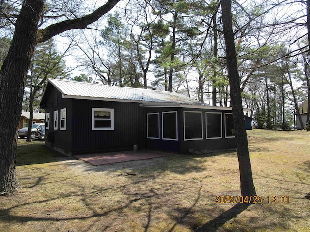 975 N Huron, East Tawas, MI 48730 - back of property featuring a lawn, metal roof, and a patio