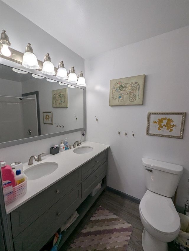 3344 E Huron, Au Gres, MI 48703 - bathroom featuring double vanity, toilet, wood finished floors, and a sink