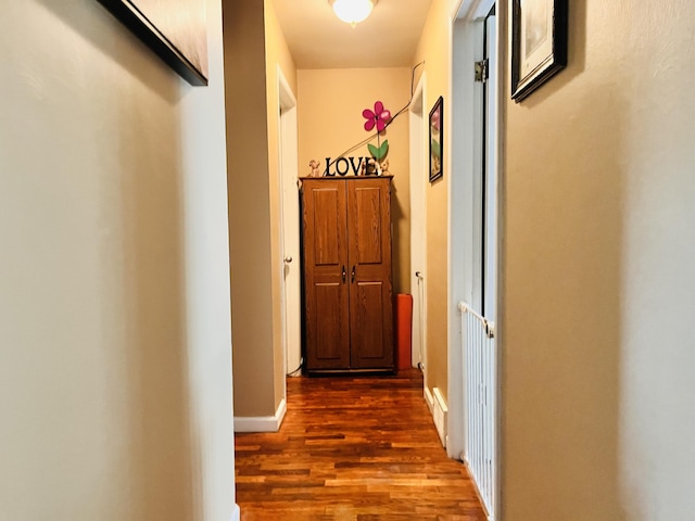 corridor with baseboards and dark wood-type flooring