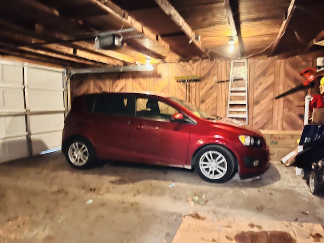 garage featuring wooden walls and a garage door opener