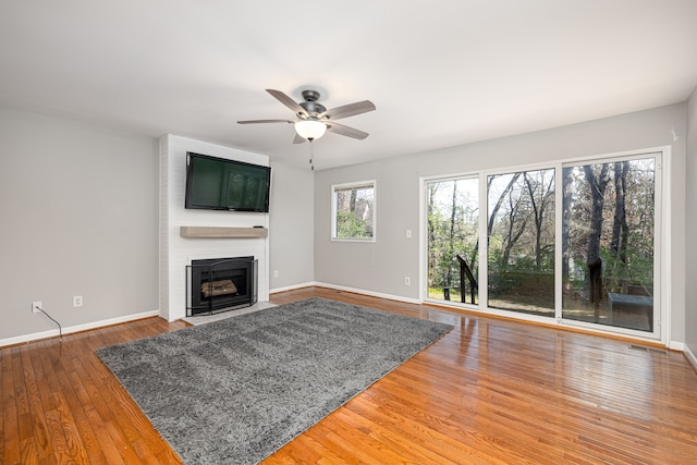 568 Foxboro Sq Unit 59, Brighton, MI 48116 - unfurnished living room featuring visible vents, wood finished floors, a fireplace, baseboards, and ceiling fan