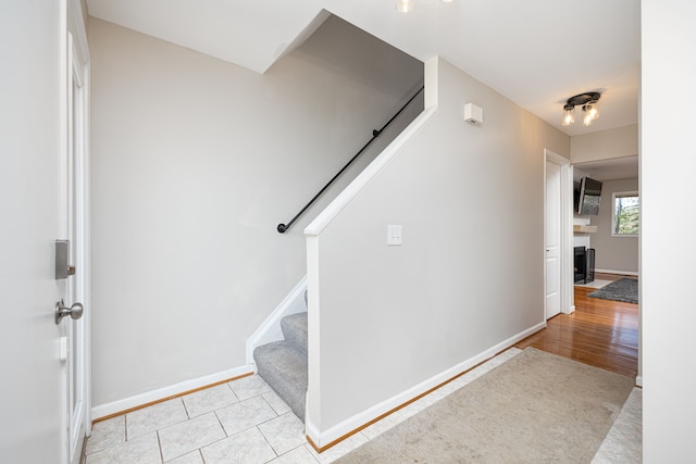568 Foxboro Sq Unit 59, Brighton, MI 48116 - interior space featuring baseboards, light tile patterned flooring, a fireplace, and stairway