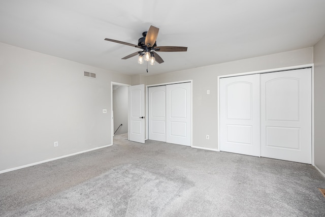 568 Foxboro Sq Unit 59, Brighton, MI 48116 - unfurnished bedroom with carpet floors, visible vents, multiple closets, baseboards, and ceiling fan
