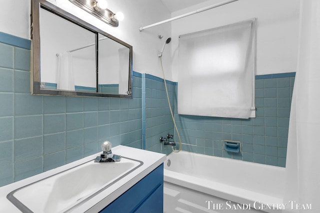 bathroom with vanity, tile walls, and shower / tub combo