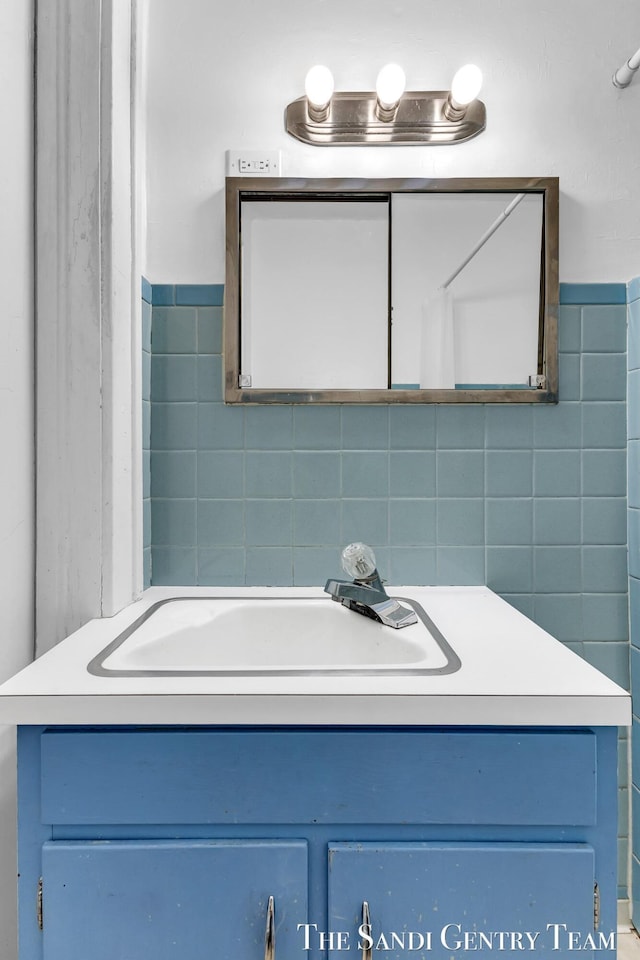 bathroom with a sink and tile walls