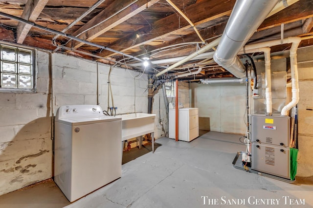 below grade area with a sink, heating unit, and washer and dryer
