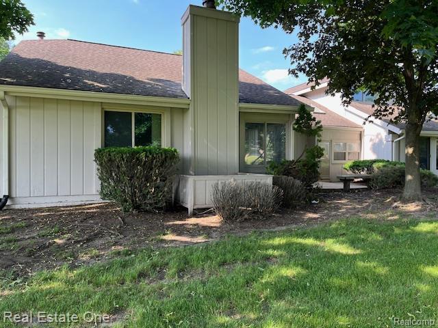 1797 Golf Ridge Dr, Bloomfield Hills, MI 48302 - view of property exterior featuring a chimney, roof with shingles, and a lawn