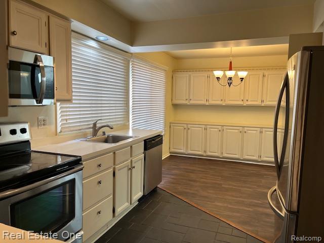 1797 Golf Ridge Dr, Bloomfield Hills, MI 48302 - kitchen with stainless steel appliances, a chandelier, white cabinetry, light countertops, and pendant lighting