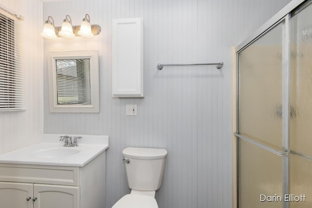 bathroom with vanity, a shower with shower door, and toilet