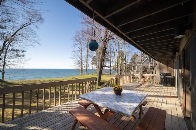 wooden terrace with a water view, grilling area, and outdoor dining space