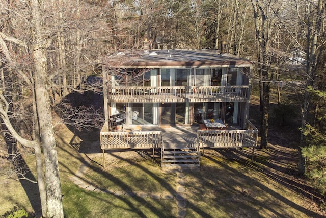 back of house featuring a wooden deck and a wooded view