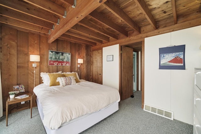 carpeted bedroom with wooden walls, wooden ceiling, beamed ceiling, and visible vents