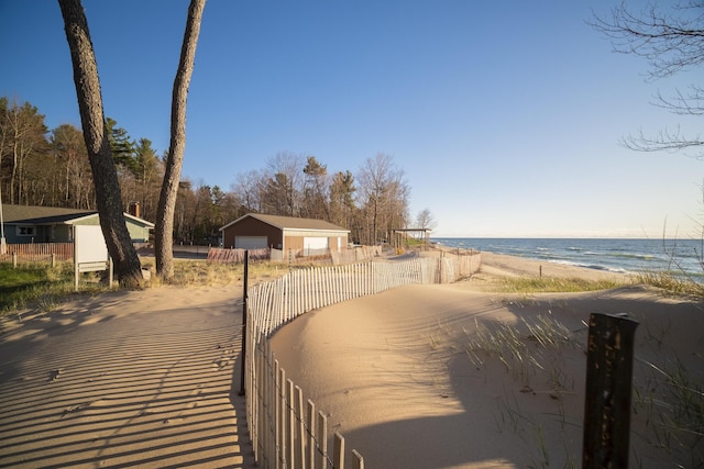 view of street featuring a beach view, a water view, and driveway